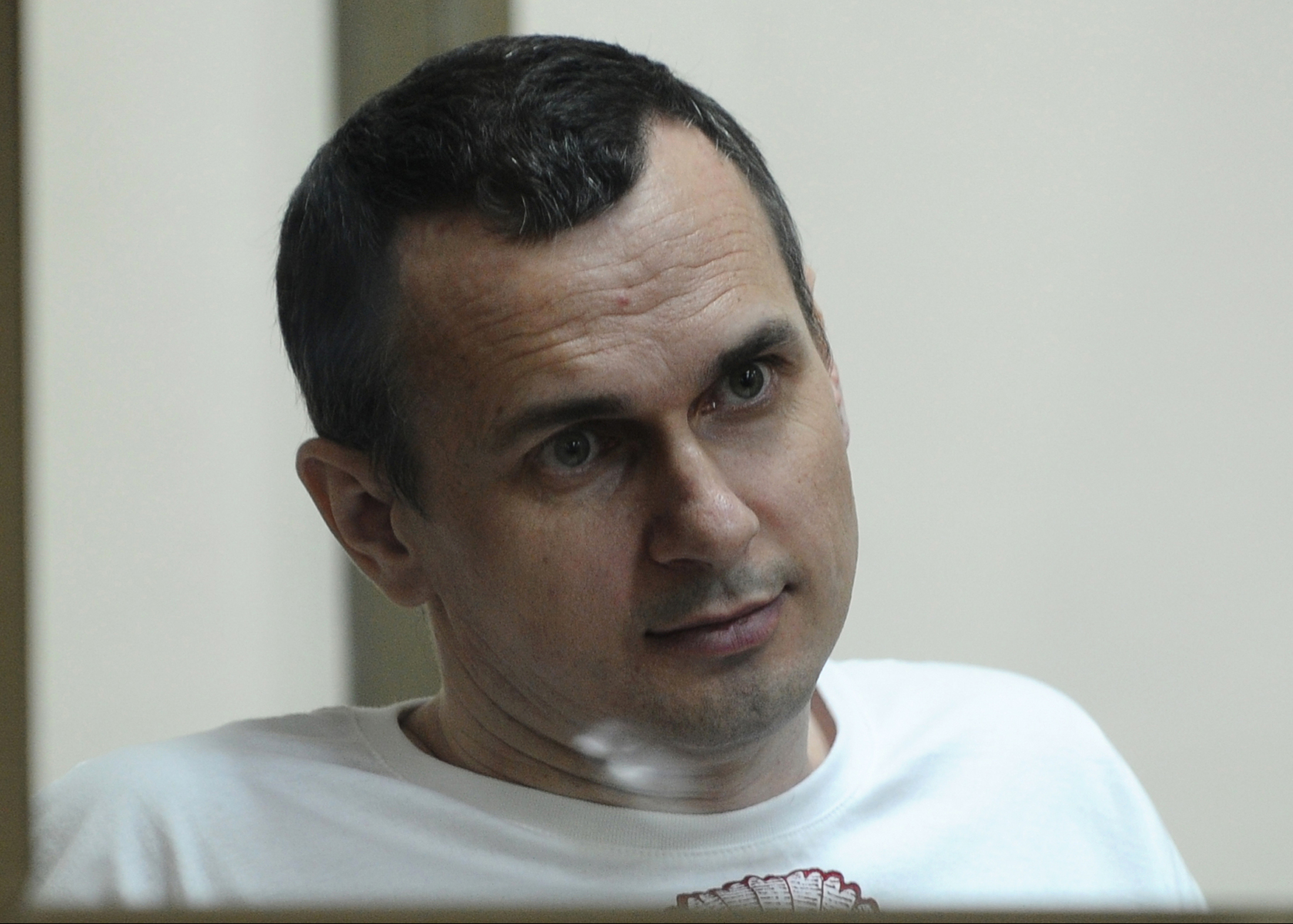 Oleg SENTSOV sits behind glass in a cage at a court room in Rostov-on-Don, Russia, Tuesday, July  21, 2015. A Ukrainian filmmaker who has been in jail for over a year now has pleaded not guilty to charges of conspiracy to commit terrorism. 39-year old Sentsov was arrested in Crimea's capital in May 2014 after a pro-Ukrainian rally protesting Russians annexation of Crimea in March that year.